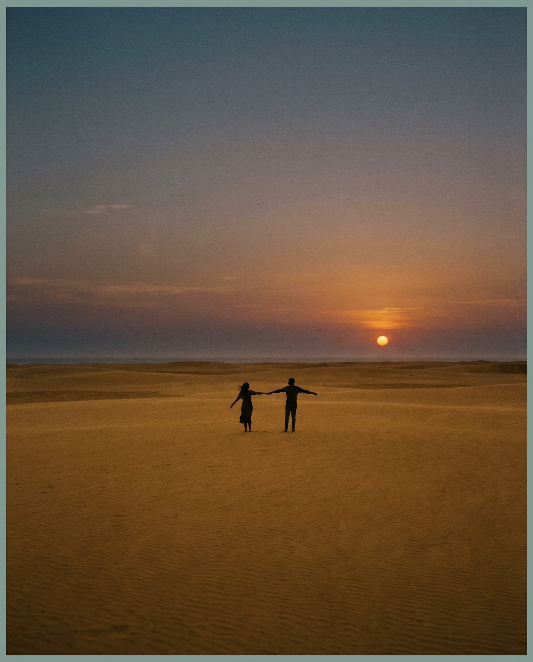 Casal caminhando à beira-mar ao entardecer